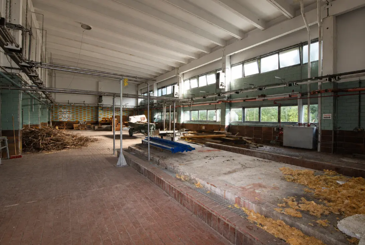 Leere Produktionshalle mit hohen Fenstern in der alten Brauerei